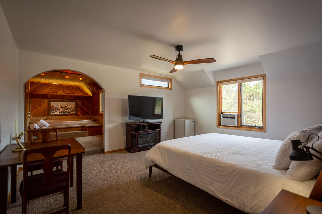 WhaleBeing Mental Health & Wellness Yoga Retreat - view of The Rancher room showing the bed and the hot tub